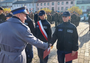 Komendant Powiatowej Policji w Tomaszowie Mazowieckim insp.Szymon Herman wręcza Natalii Rybińskiej list gratulacyjny